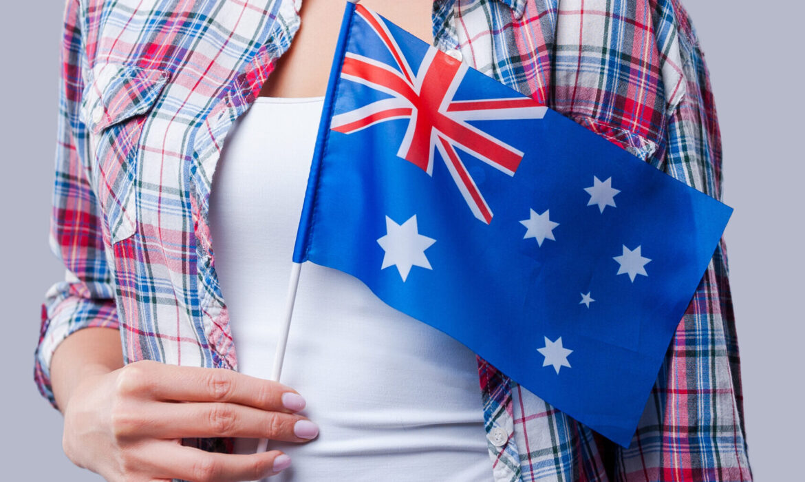 Beauty with Australian flag. Happy young women flag of Australia while standing against grey background