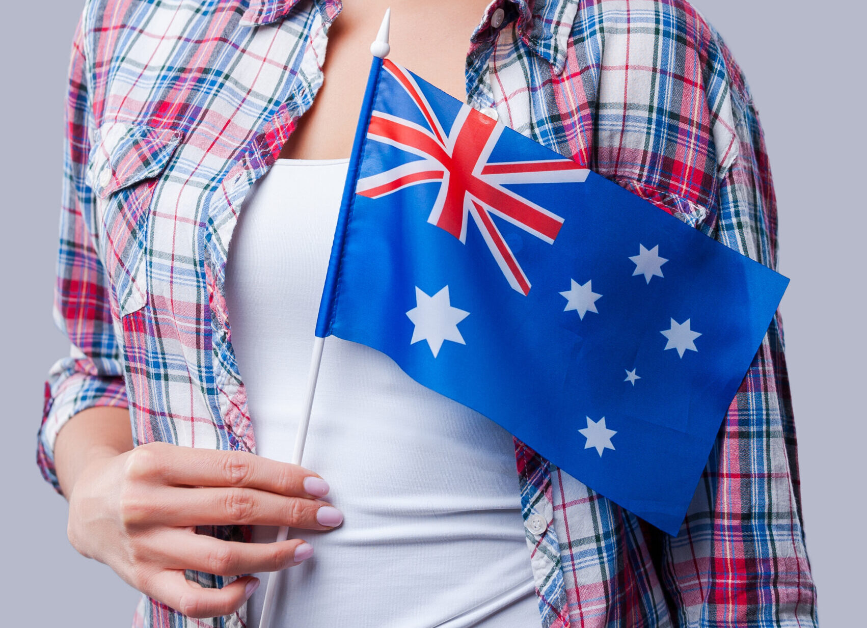 Beauty with Australian flag. Happy young women flag of Australia while standing against grey background