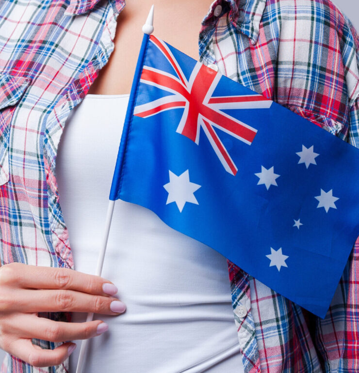 Beauty with Australian flag. Happy young women flag of Australia while standing against grey background